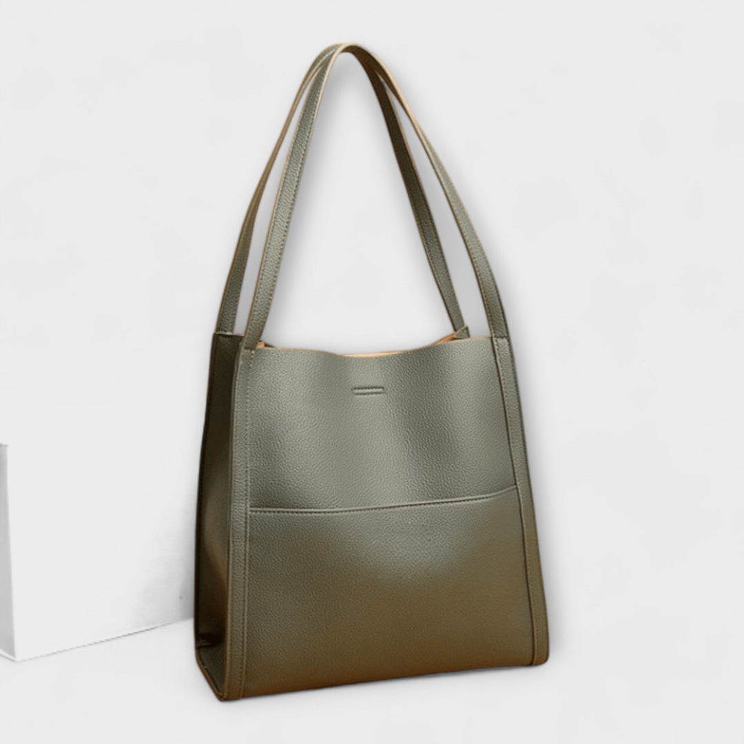Women's classic structured handbag displayed with a business outfit, a professional work bag.