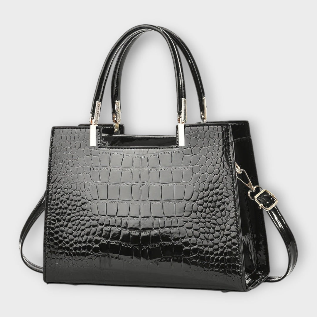 Elegant women's black structured handbag with top handle and gold hardware, ideal fashion accessory.