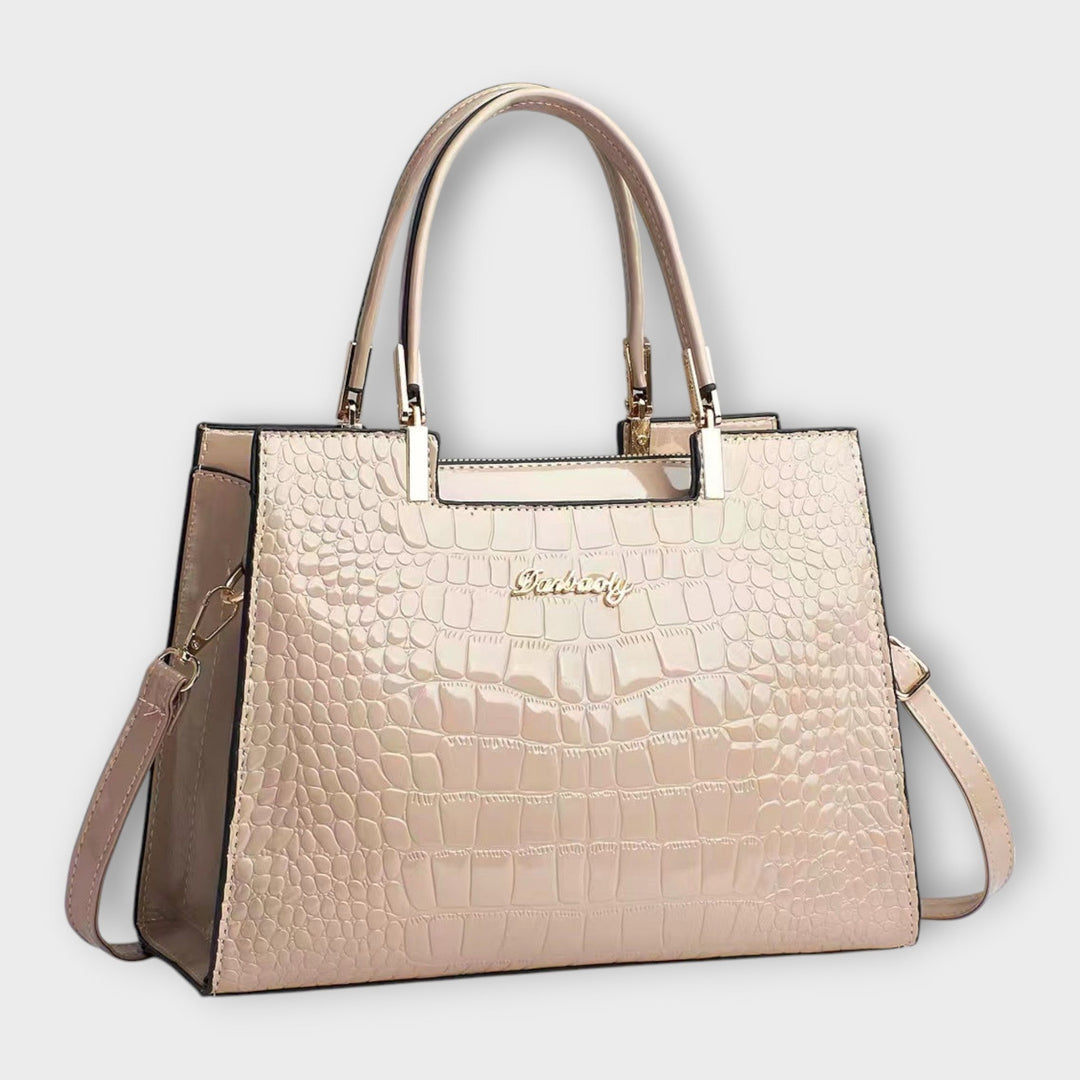 Fashionable women's black handbag with top handle, emphasizing its timeless design and elegance.
