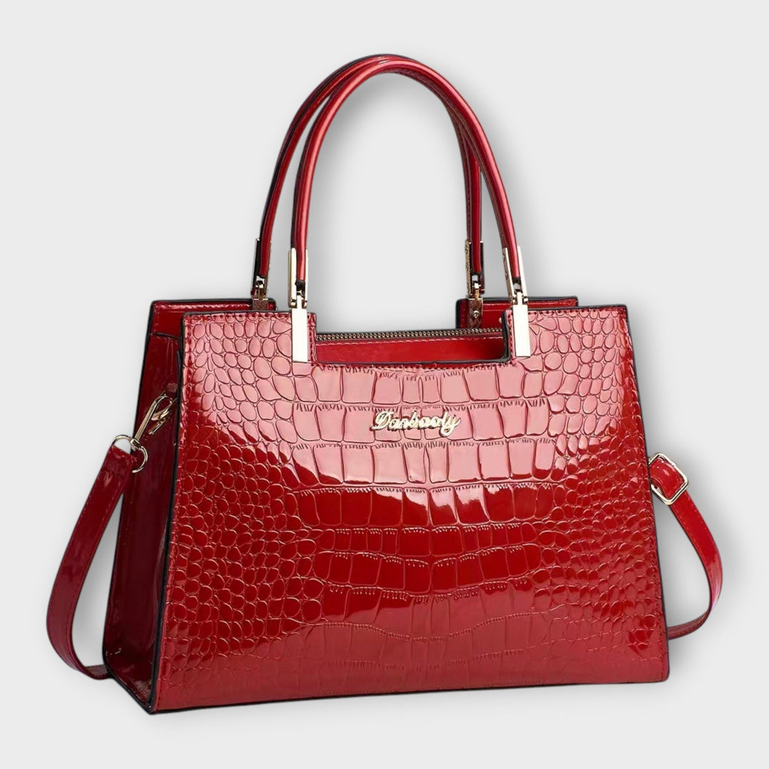 Black structured top handle purse, open, revealing a glimpse of its organized interior for women.