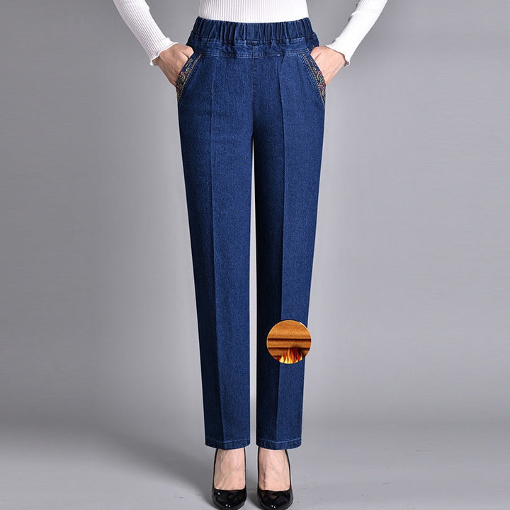 Stack of folded women's comfort-fit jeans with elastic waist, ready for casual fall and winter outfits.