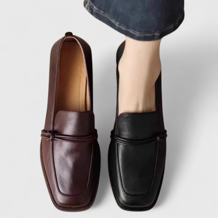 Pair of women's classic slip-on loafers in navy blue, offering comfort and timeless style for versatile wear.