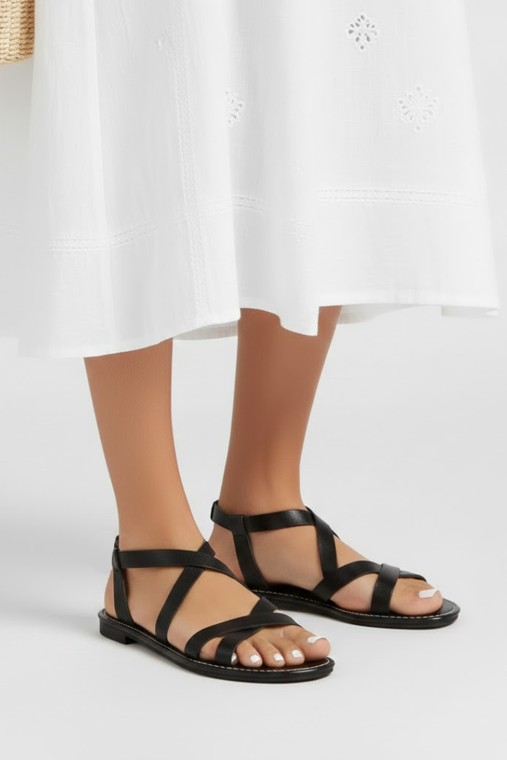 Close-up of women's flat sandals featuring soft criss-cross straps, highlighting the comfortable design.