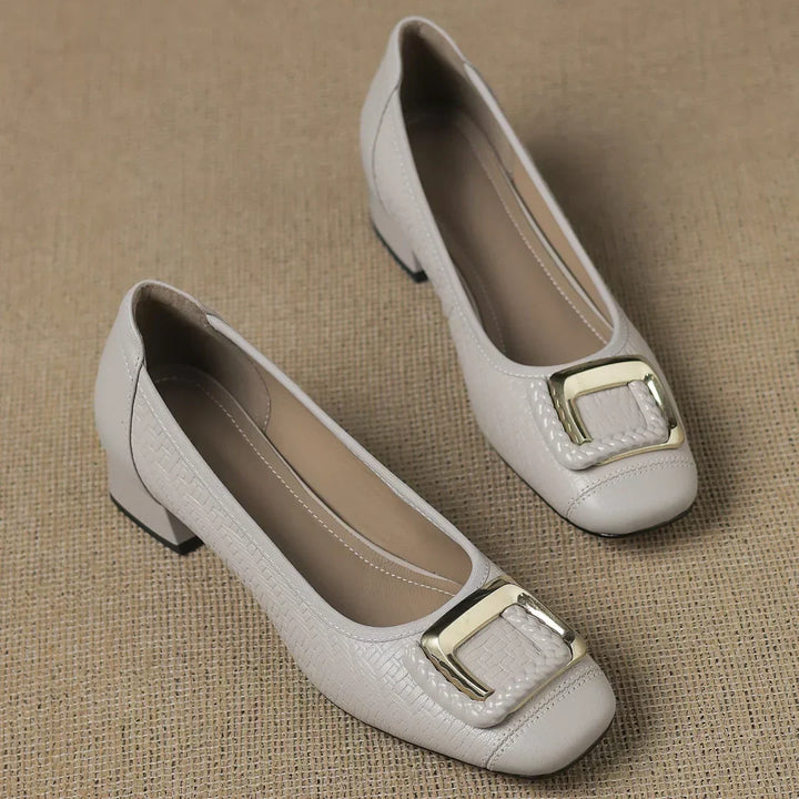 Stylish women's black block heel pumps featuring a low heel, square toe, textured finish, & elegant gold buckle