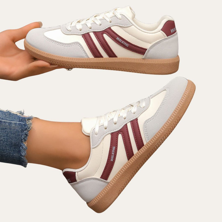 Woman walking in comfortable white low top casual sneakers, showcasing versatile spring footwear.
