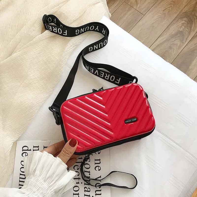 Trendy hard shell compact travel handbag for women; durable, waterproof mini crossbody purse.