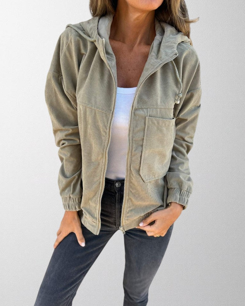 Close-up of women's zip-up corduroy jacket, highlighting the fabric texture and hooded design.