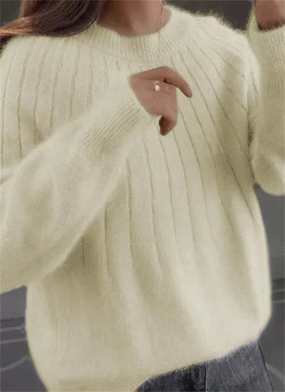Woman smiling, wearing a fashionable knit sweater, showcasing its comfortable and casual style.