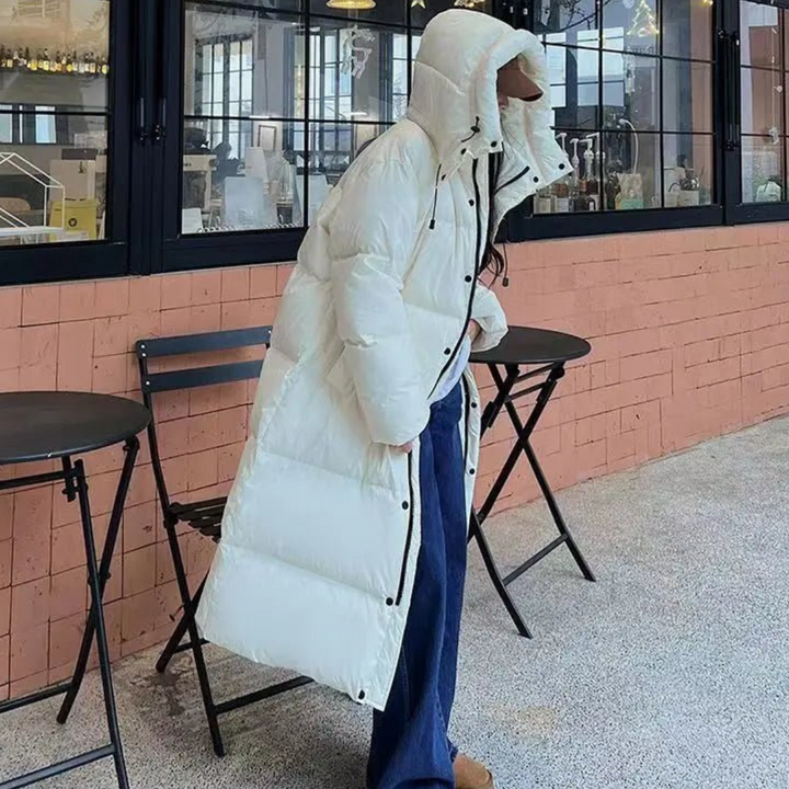 Warm women's long puffer jacket with a hood, ideal for winter. Cozy outerwear for casual fashion & cold weather essentials.