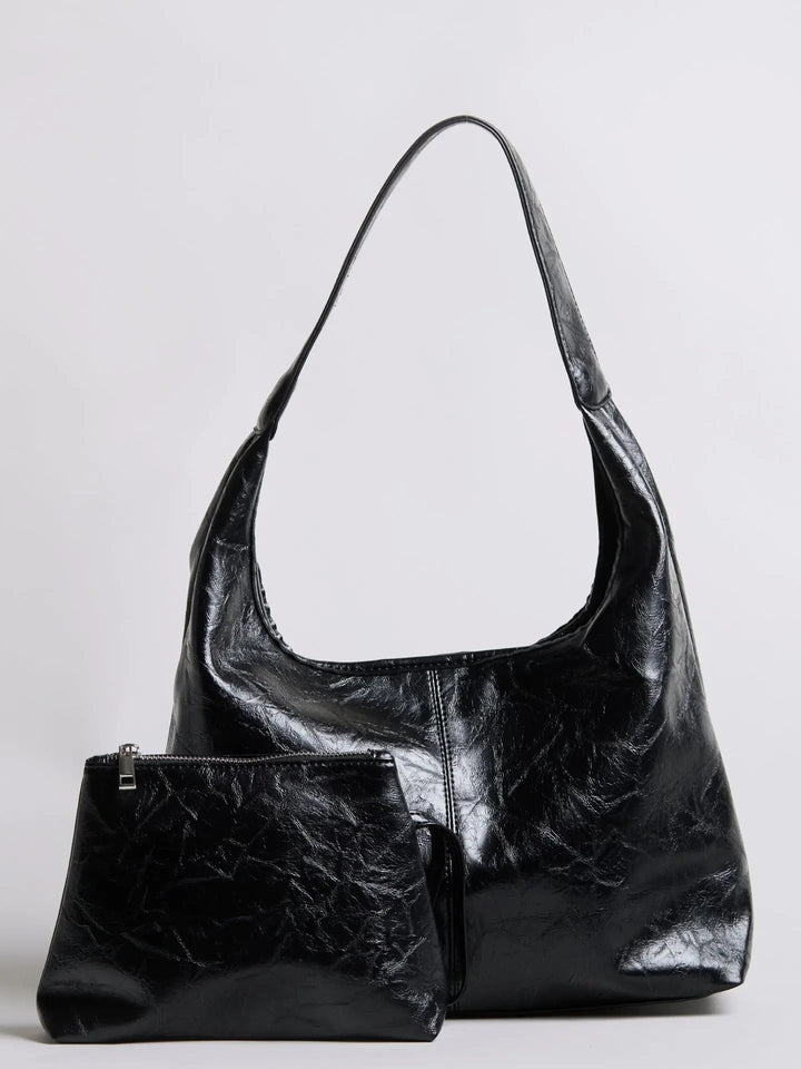 Distressed leather tote on a hanger, showcasing its structure and form