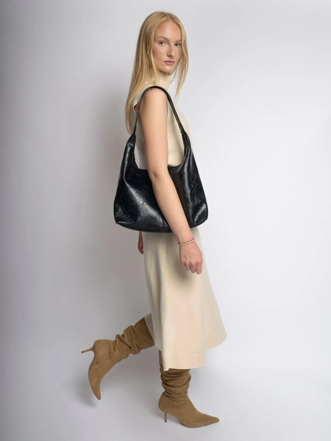 Distressed leather tote against a window, natural light enhancing texture