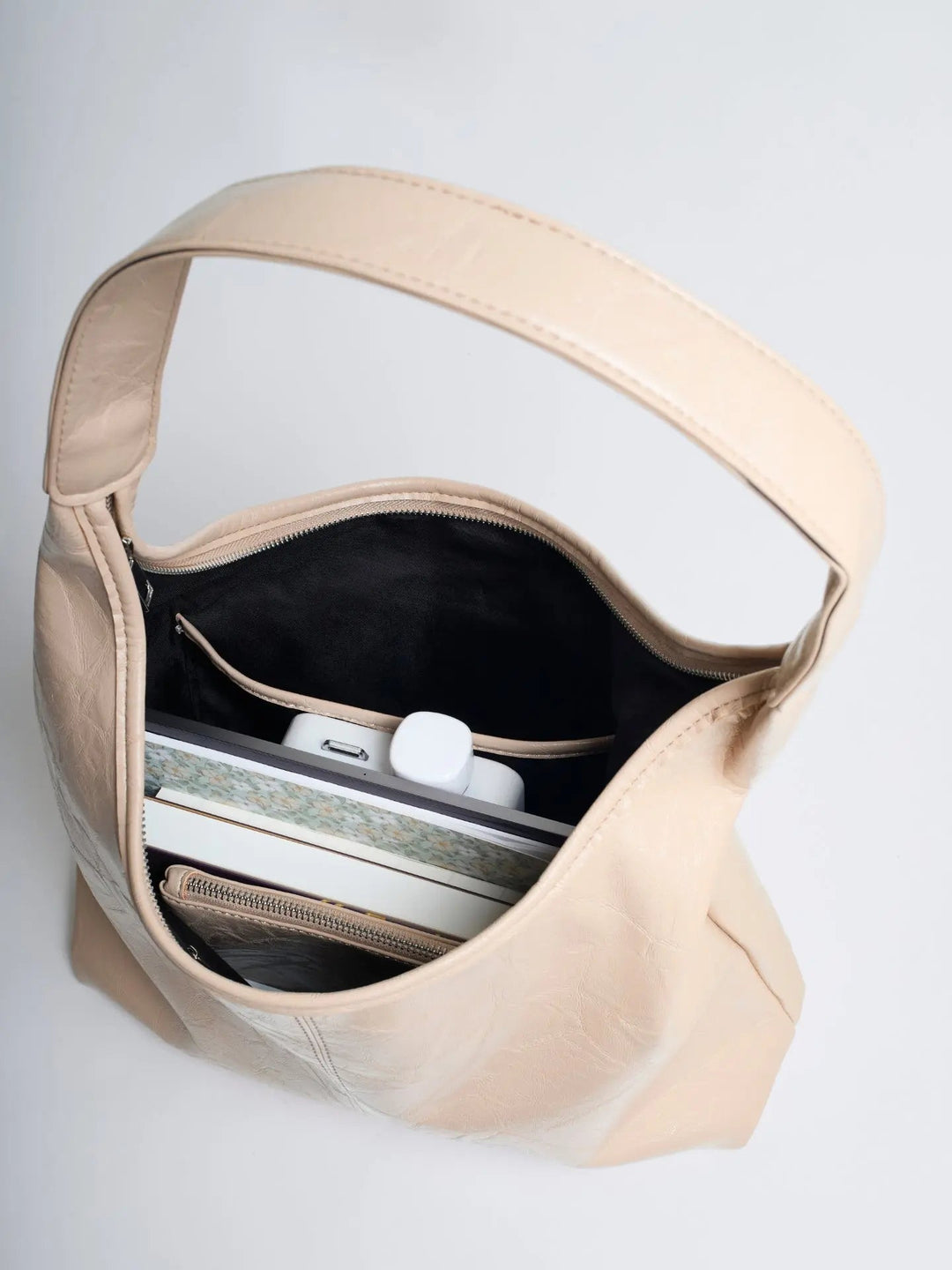 Distressed leather tote with a zip-top closure, securing women's belongings