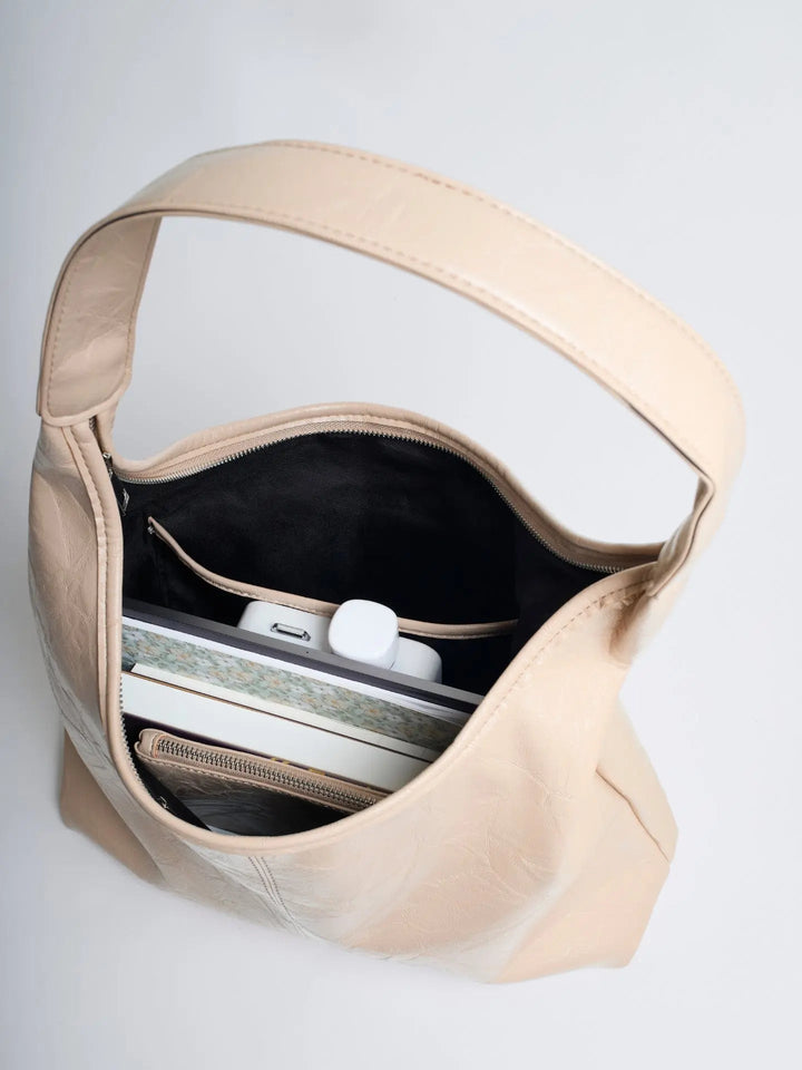 Distressed leather tote with a zip-top closure, securing women's belongings