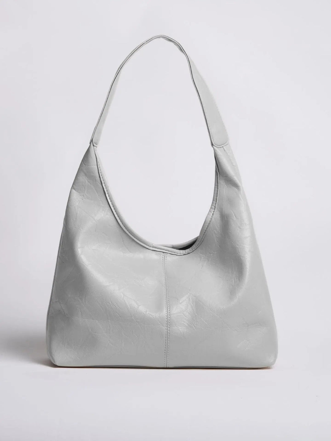 Distressed leather tote against a brick wall, showcasing its rustic charm