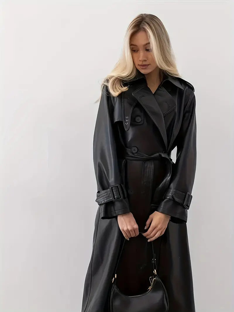 Fashionable women's black faux leather trench coat with double-breasted design and belt.