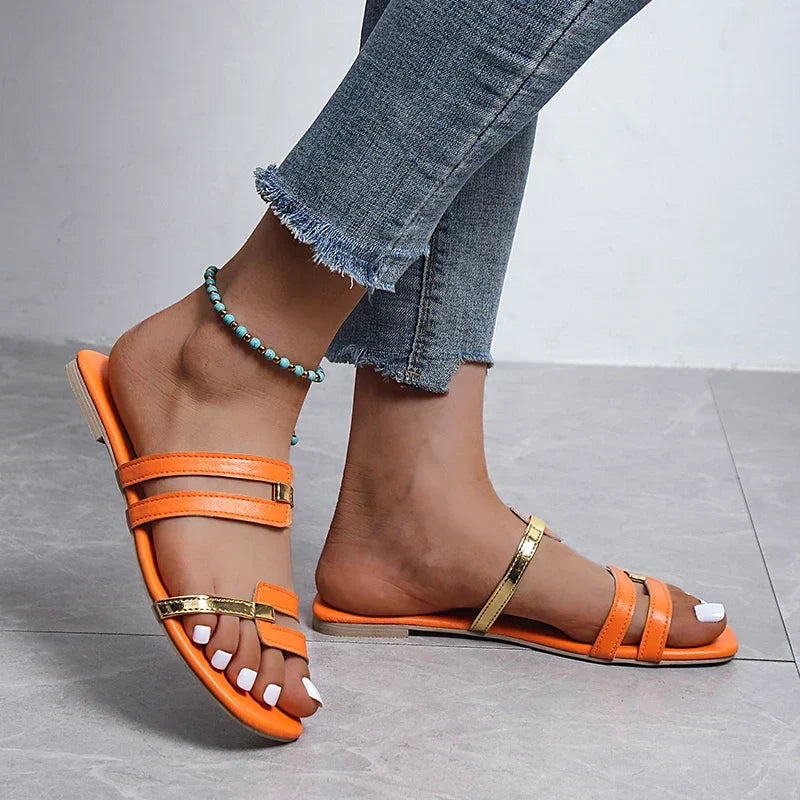 Women's double strap flat sandals with elegant gold detail, perfect for summer casual wear.