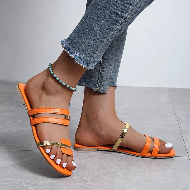 Women's double strap flat sandals with elegant gold detail, perfect for summer casual wear.