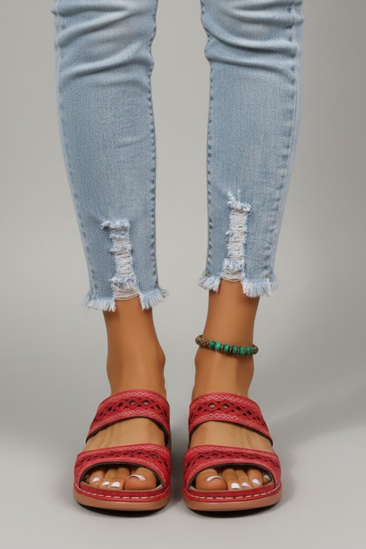 Pair of black women's slide sandals with stylish dual straps and cutout details, top view.