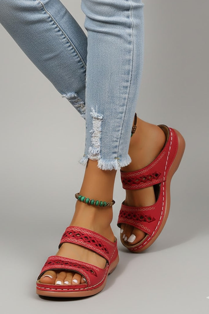 Casual women's flat slide sandals in brown with dual straps and intricate decorative cutouts.