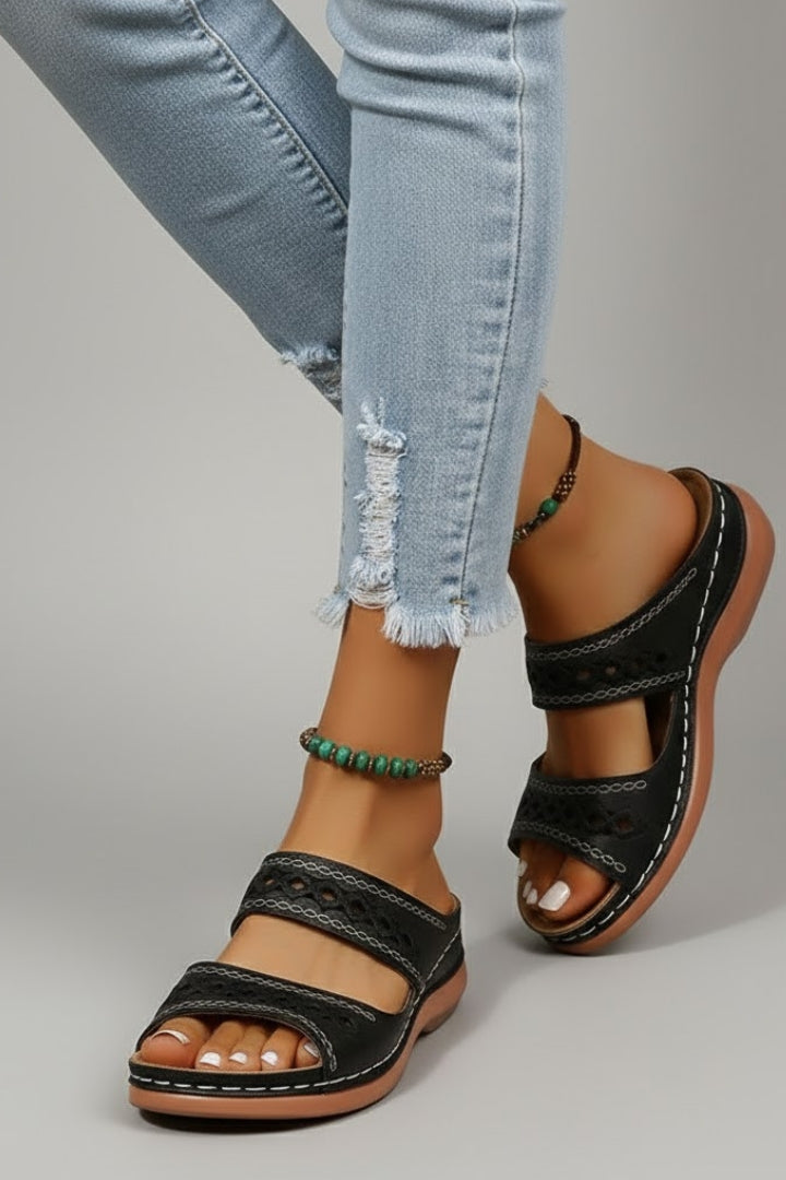 Full view of women's dual strap slide sandals with decorative cutouts, emphasizing comfort and style.