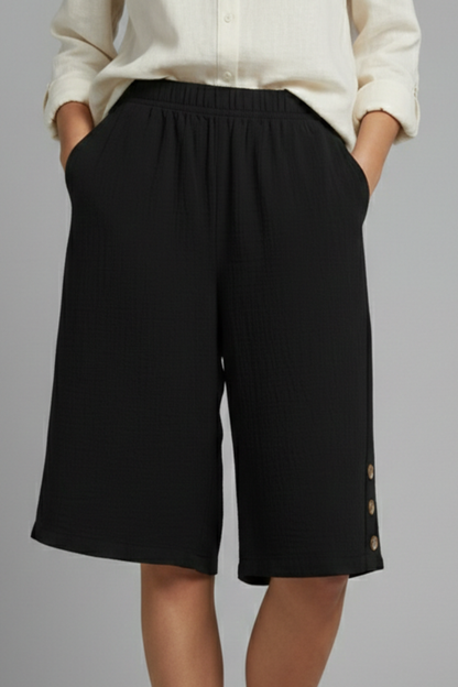 Fashionable women's shorts: wide leg, elastic waist, and stylish button detail, great for summer.