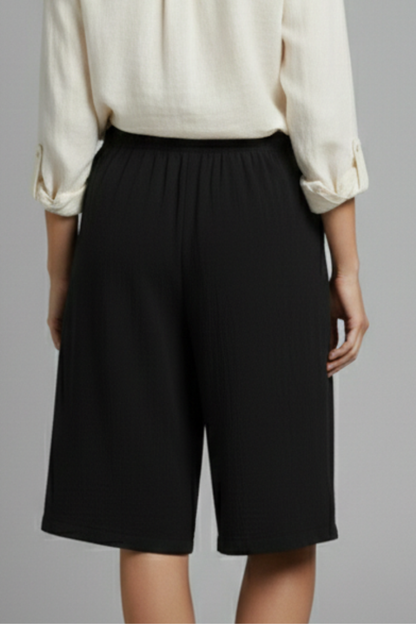 Chic women's shorts; elasticated waist, wide leg cut, and decorative buttons, a summer essential.
