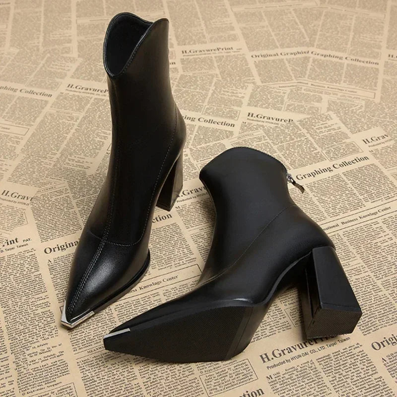 Close-up of a women's black pointed toe spring ankle boot with a sleek design.