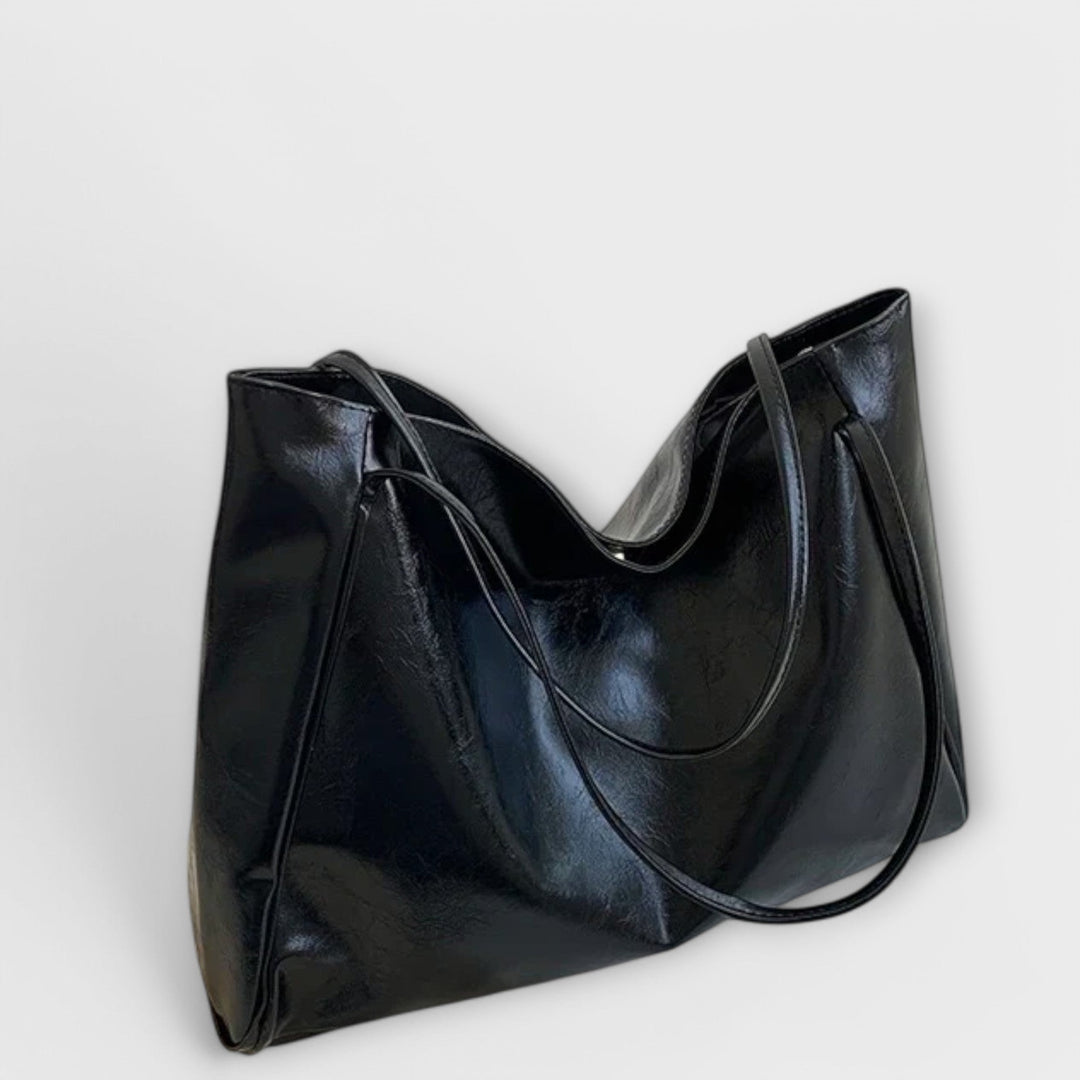 Front view of an elegant black women's tote bag, featuring sturdy handles