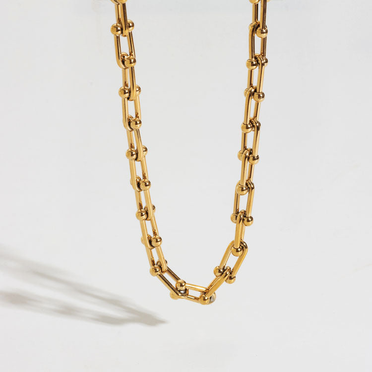 Thick gold steel chain necklace for women with unique horseshoe U-clasp, a stylish and elegant statement piece.