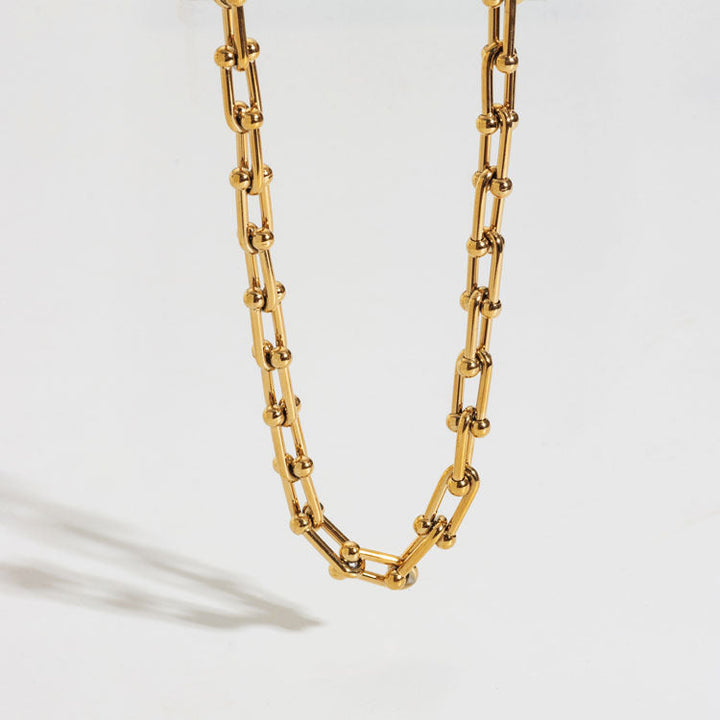Thick gold steel chain necklace for women with unique horseshoe U-clasp, a stylish and elegant statement piece.