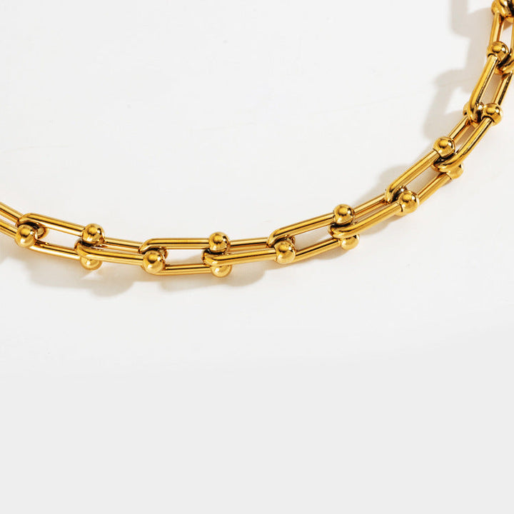 Statement gold steel thick chain necklace for women with a unique horseshoe U-clasp design, elegant fashion jewelry.