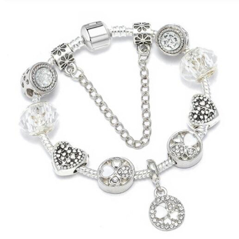 Delicate women's charm bracelet featuring peach blossom motif. Elegant fashion accessory, perfect for daily wear.