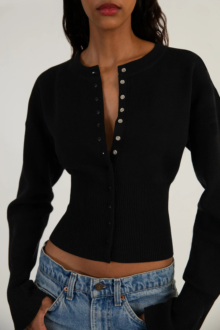 Contemporary women's fitted cropped knit cardigan with long sleeves and front buttons. Ideal for layering.