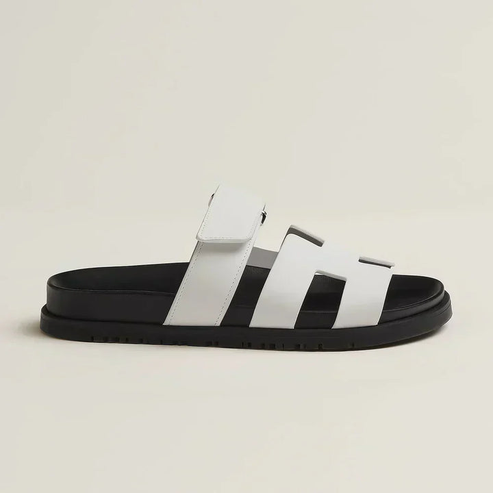 Pair of white women's summer flat sandals with adjustable straps, great for casual outings.