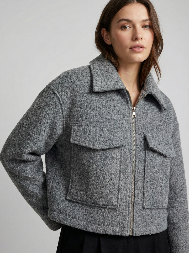 Gray women's cropped jacket featuring a zip closure & practical front pockets for a modern fit.