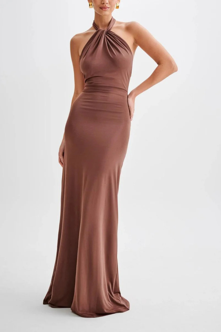 Elegant women's halter neck bodycon maxi dress. Open back and twisted knot for a chic wedding guest outfit.