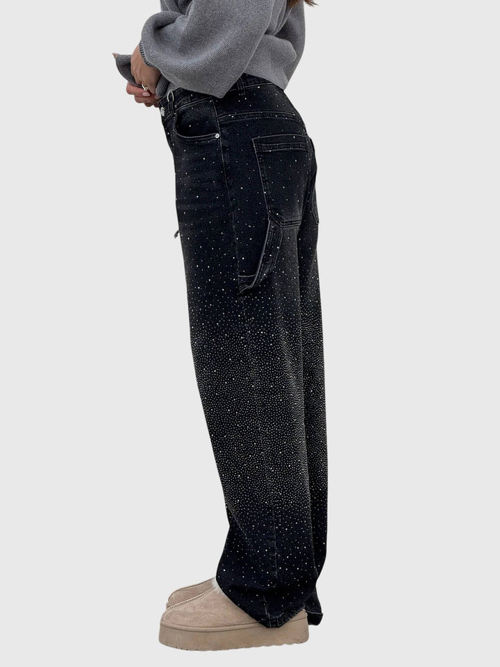 Detail of the wide-leg cut on women's high-rise denim pants with sparkle diamond accents.