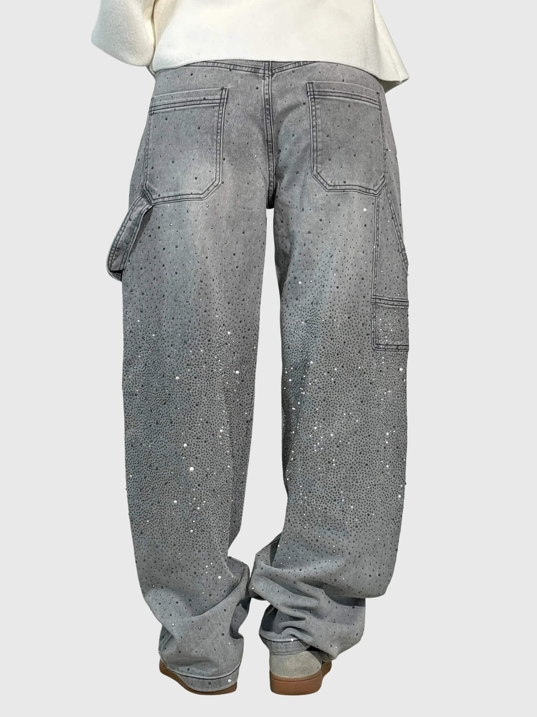 Close-up on the waist of women's high-rise wide-leg denim pants, showcasing the sparkle embellishment.