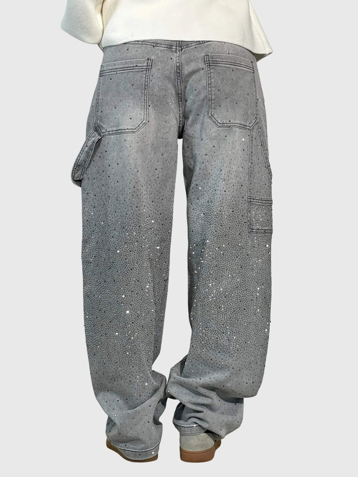 Close-up on the waist of women's high-rise wide-leg denim pants, showcasing the sparkle embellishment.