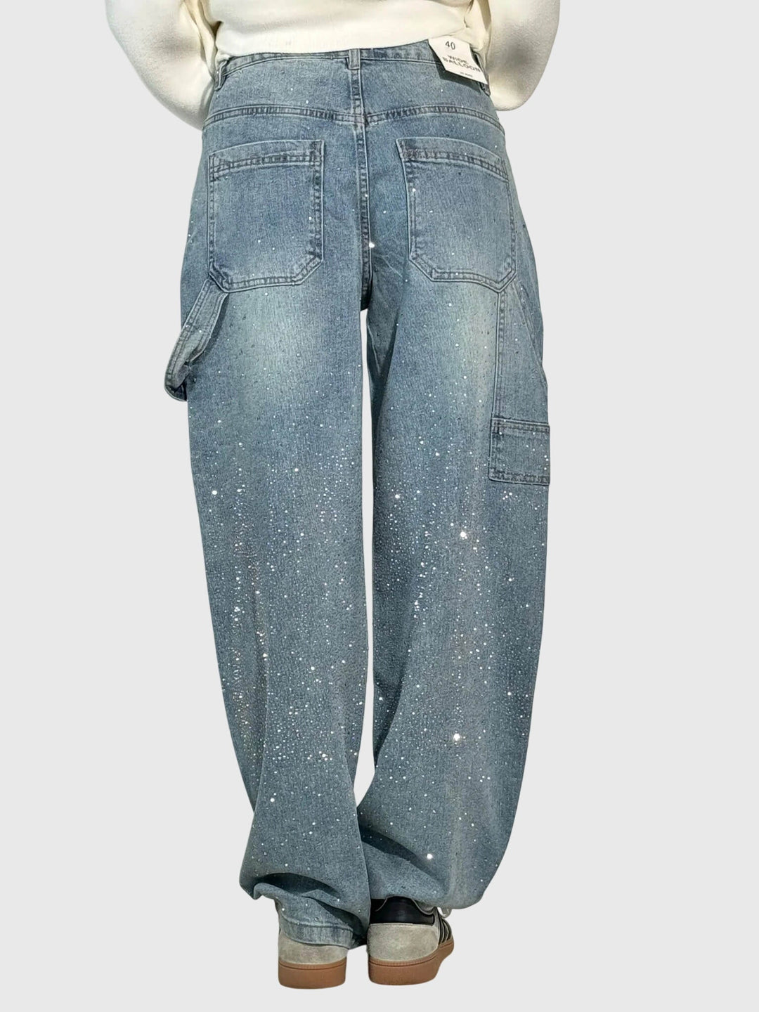 Textured image of women's denim fabric with embedded sparkle diamonds on wide-leg pants.