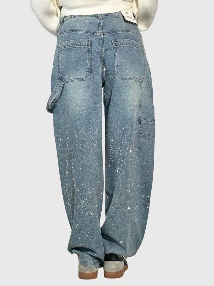 Textured image of women's denim fabric with embedded sparkle diamonds on wide-leg pants.