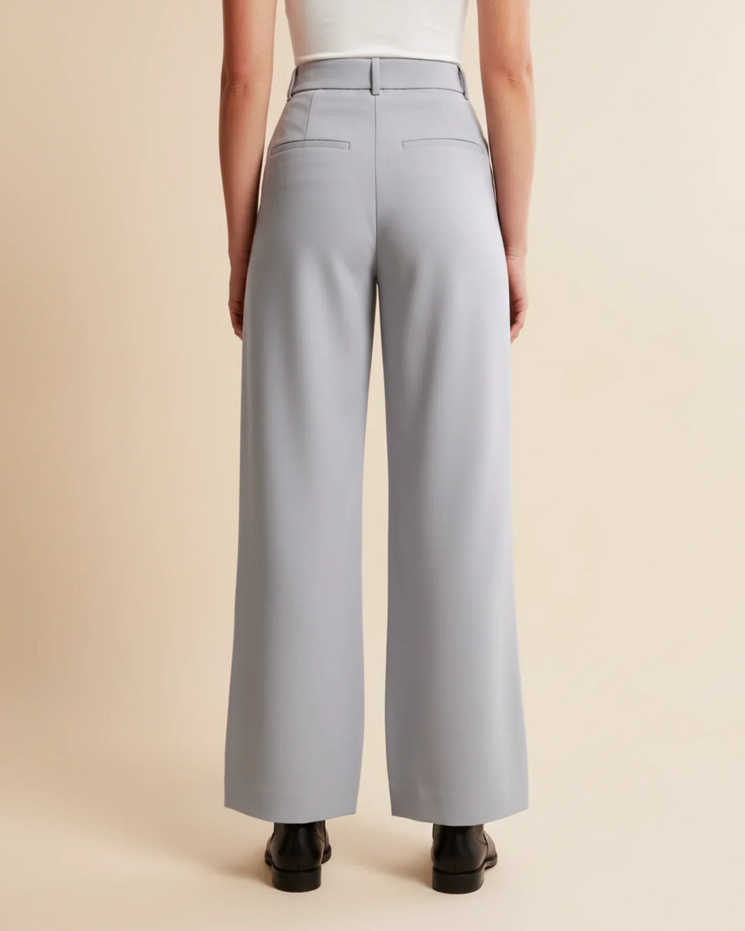 Close-up of the tailored finish and pleating on women's high waist casual pants.