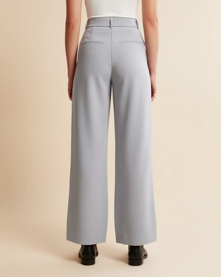 Close-up of the tailored finish and pleating on women's high waist casual pants.