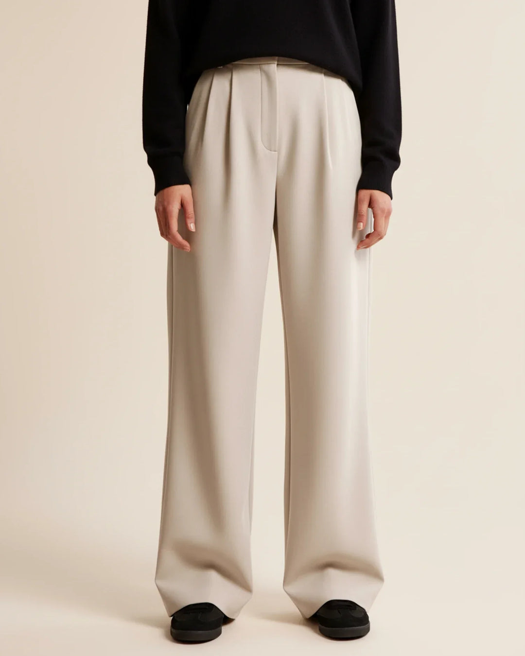 Beige high-waisted pleated tailored trousers for women, showcasing a comfortable and modest fashion style.