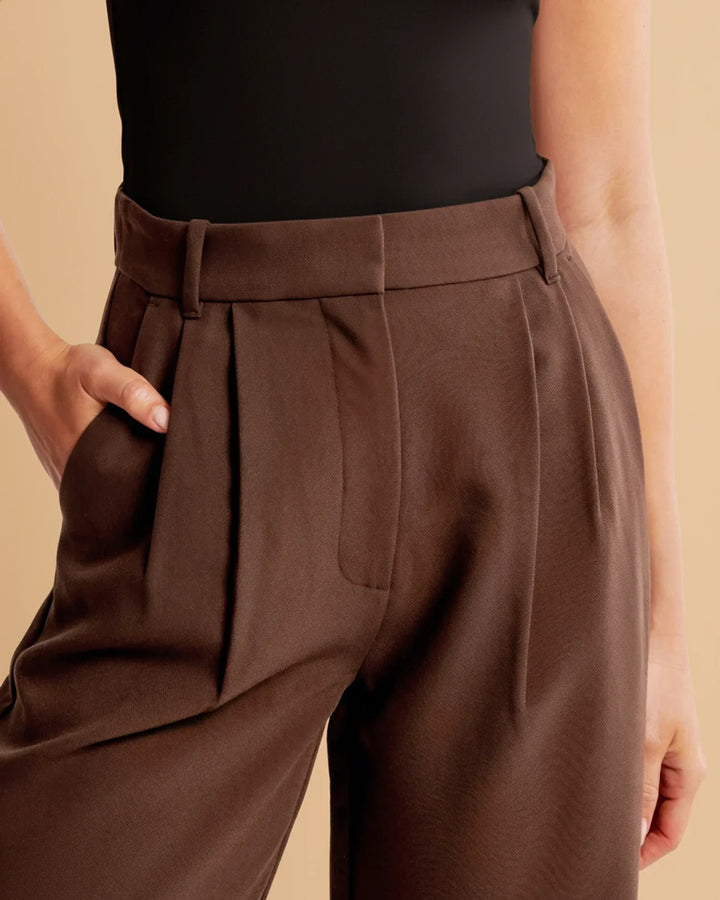 Fashionable women's high-waisted pleated tailored trousers in a bright color, a statement piece.