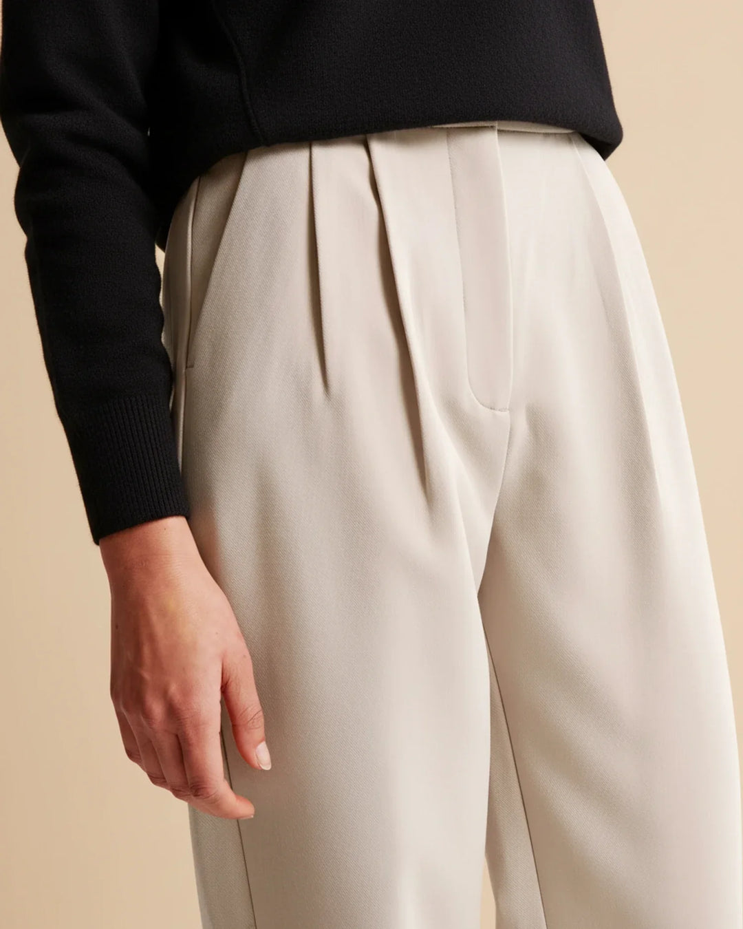Navy blue women's tailored pants with a high waist and pleats, ideal for professional officewear.