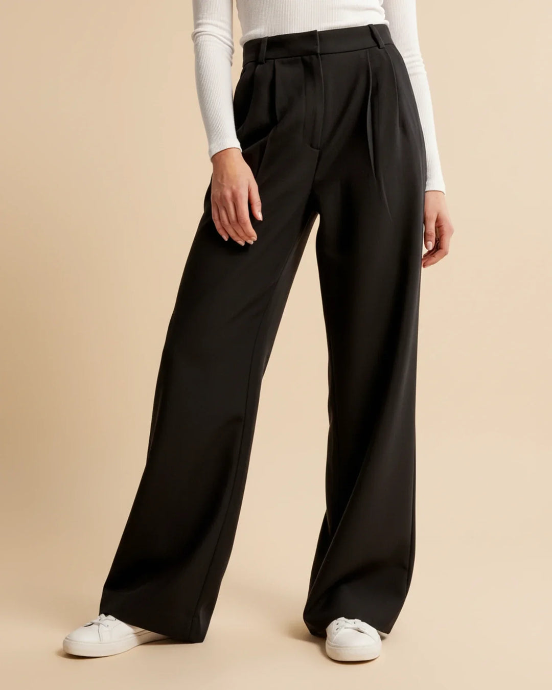 Side profile of women's tailored high waist pleated trousers, demonstrating their elegant fit.
