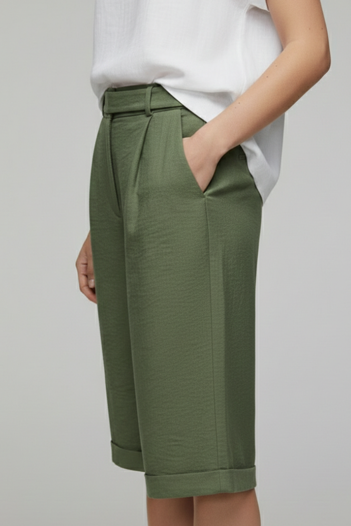 Close-up of the cuffed hem and high-waist detail on women's khaki tailored shorts.