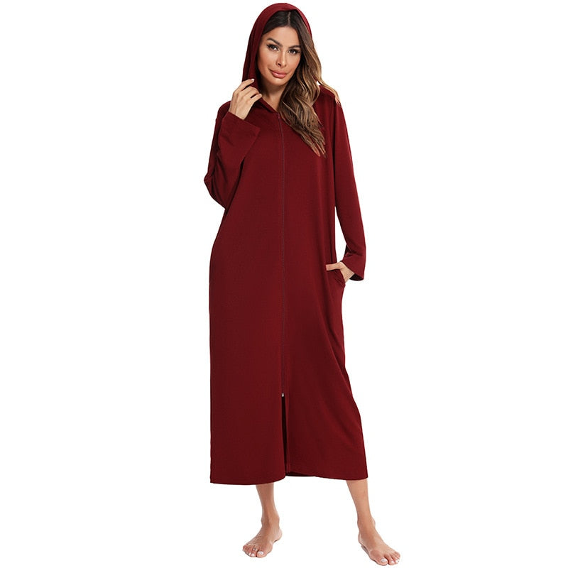 Woman wearing a plush hooded zip-up fleece nightdress, lounging comfortably at home