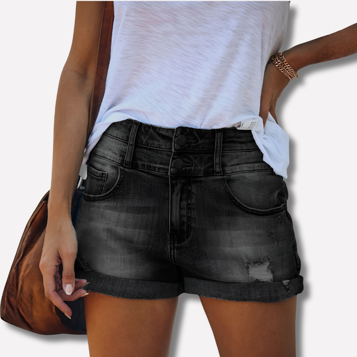 Model wearing women's light wash ripped denim shorts, styled for summer comfort.